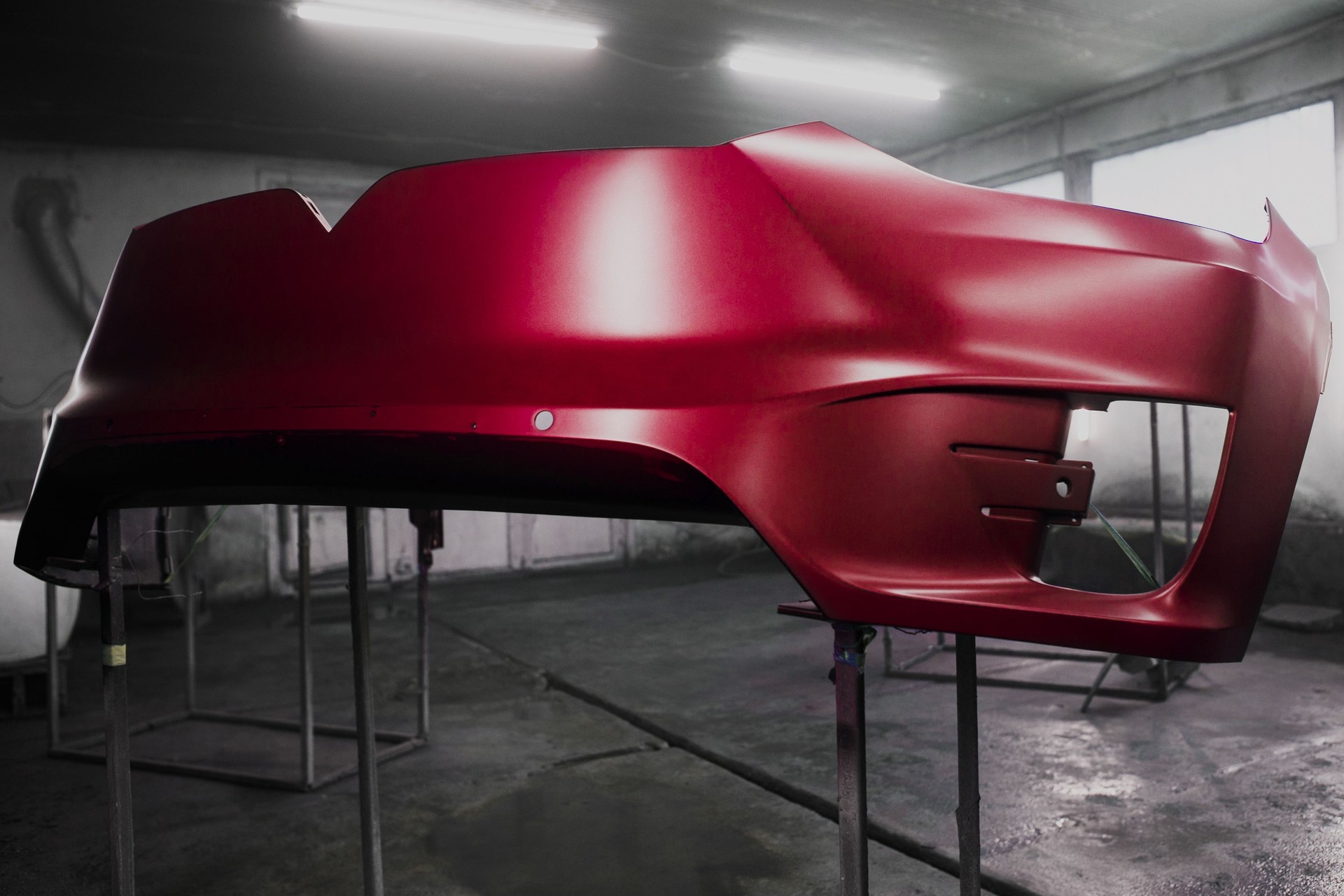 Painted parts of car body using spray gun, drying body in the paint chamber after applying the paint coating, final work on restoration car body after accident.