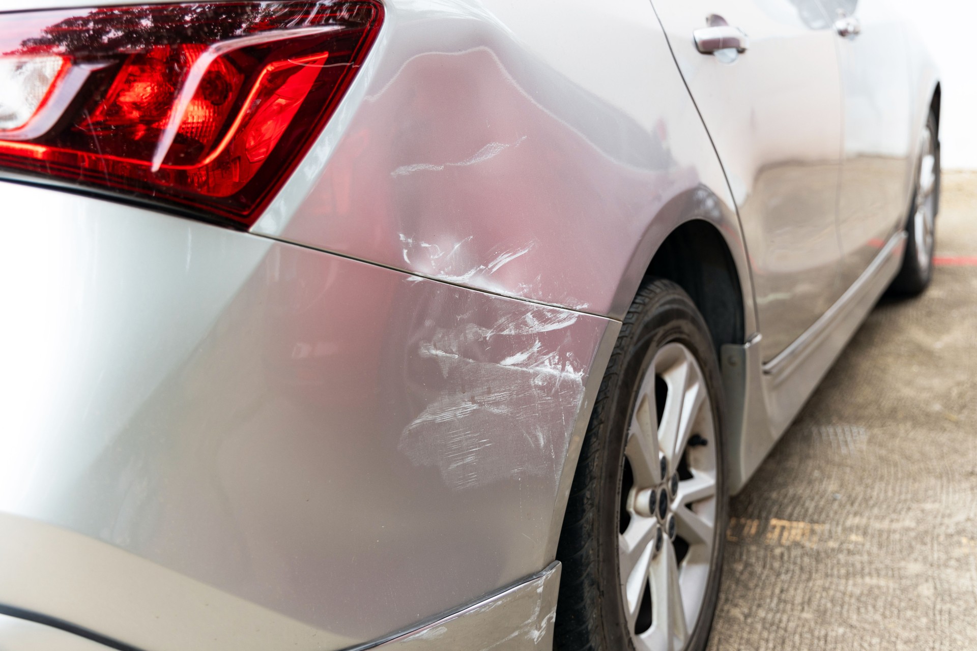 Dreaded scratch down the side car get damaged from accident on the road. Vehicle bumper dent and taillight broken by car crash.