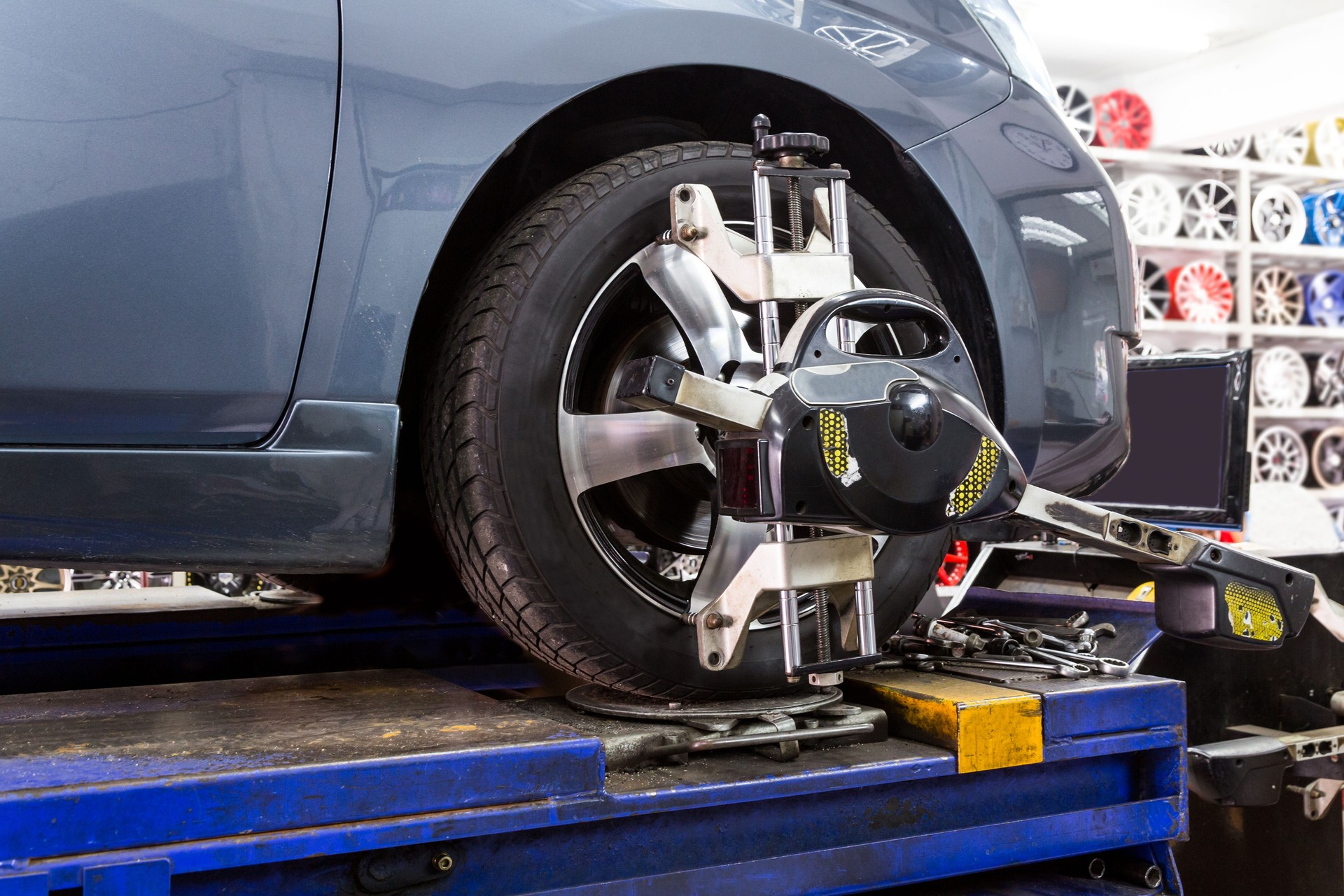 Closeup of tire clamped with aligner undergoing auto wheel align