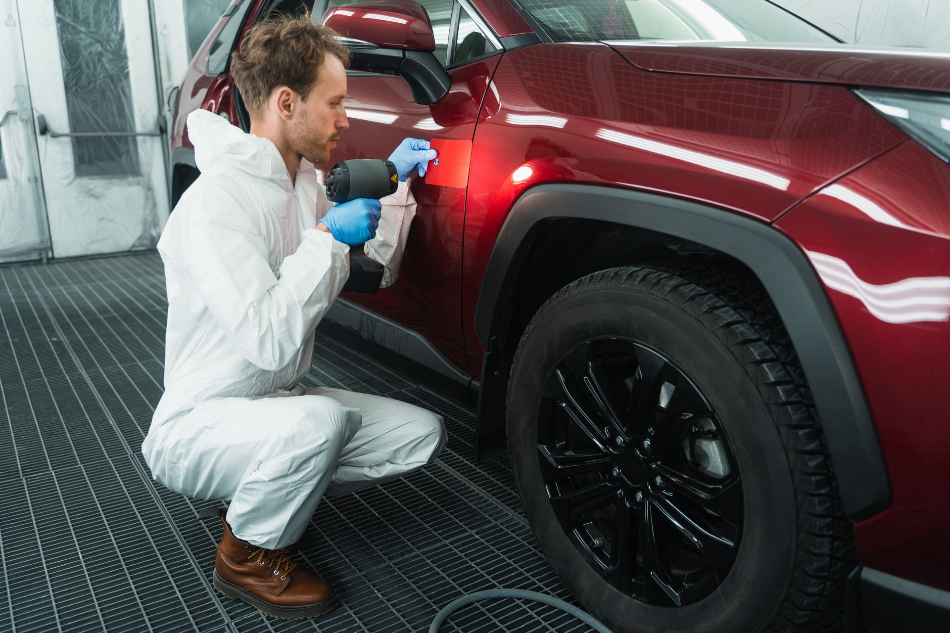 Professional auto painter matches car paint color with lamp and samples