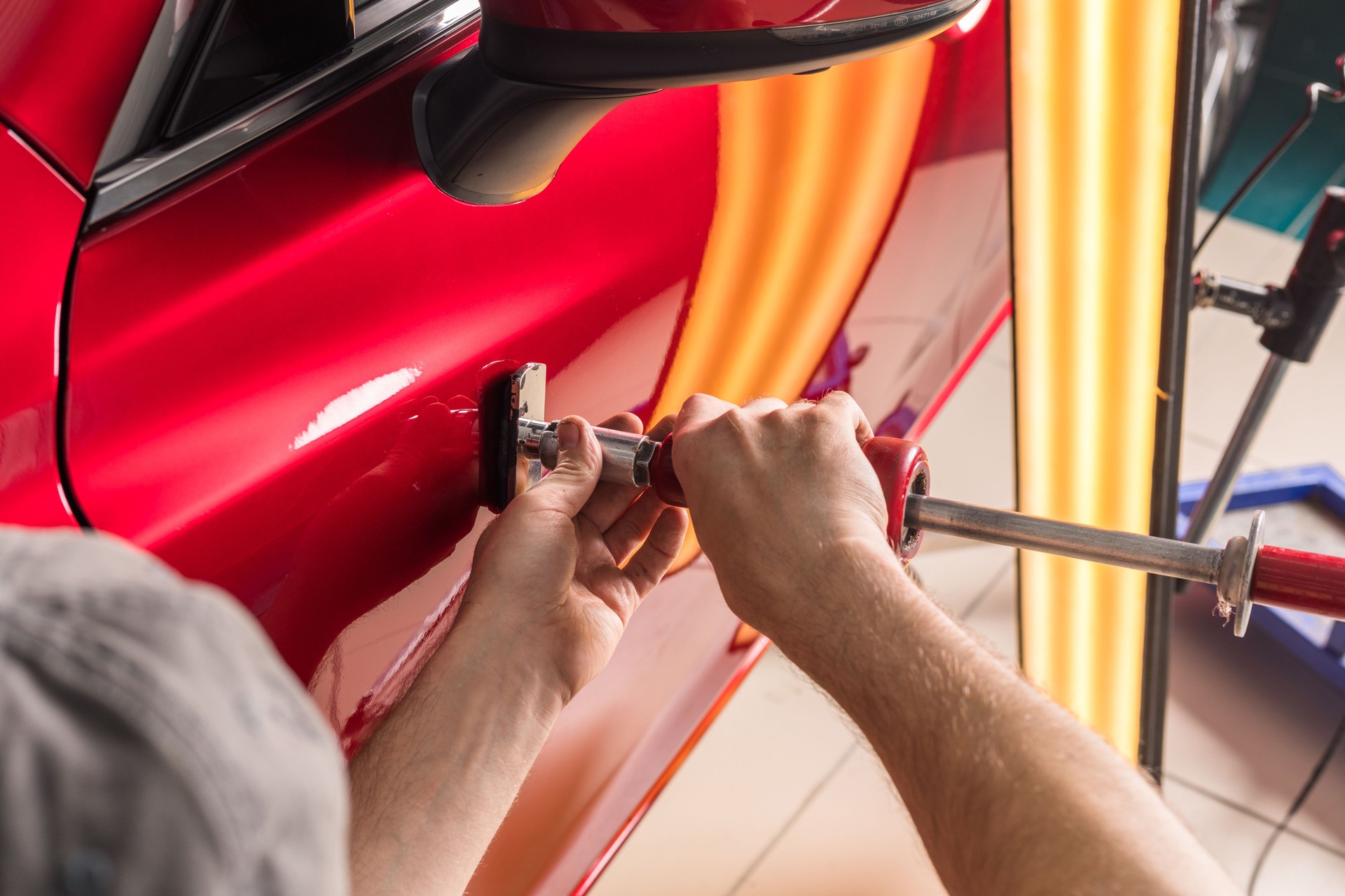 The technician removes dents on the car using the method without painting. PDR. Car body repair.